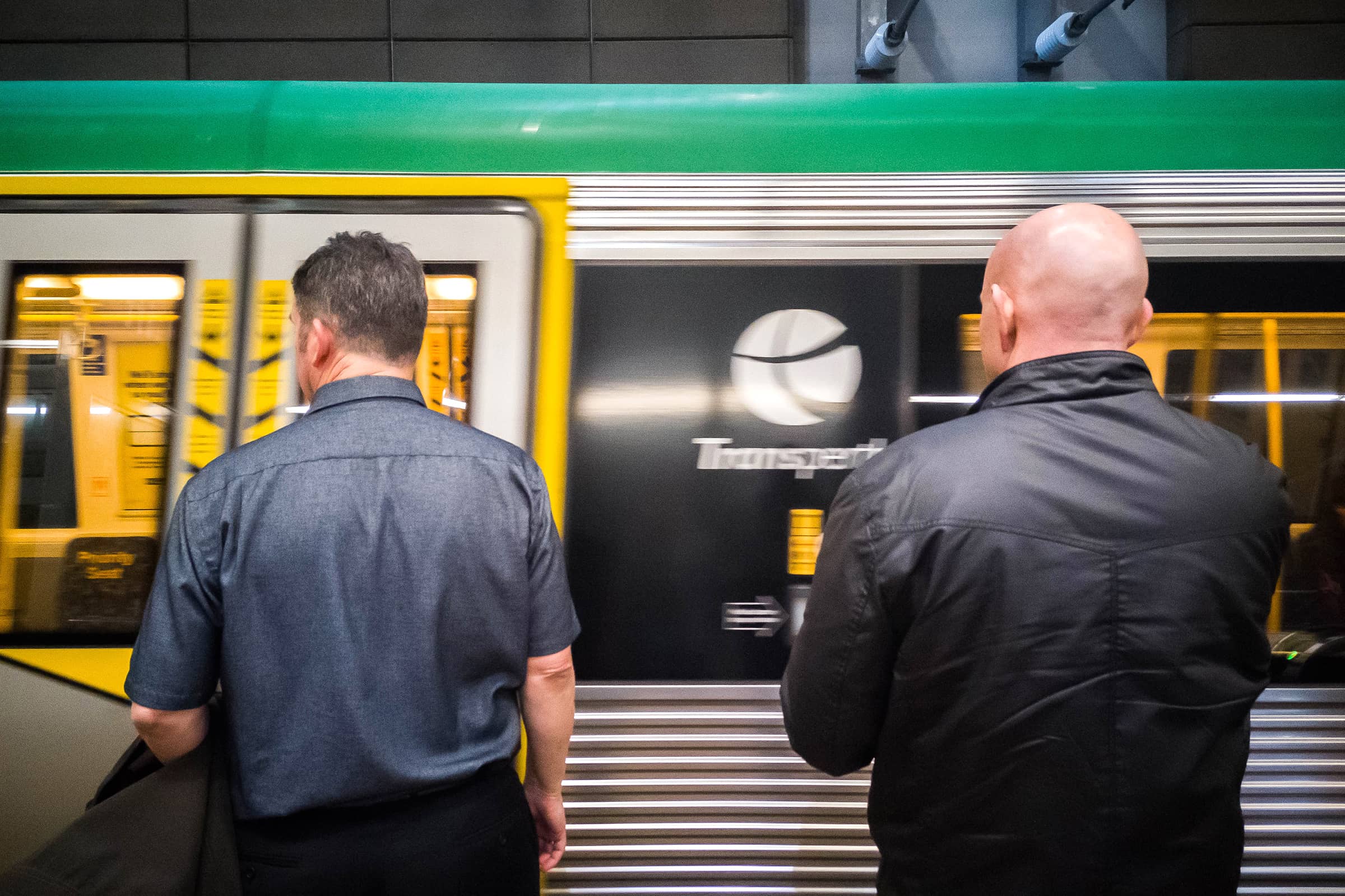 Transperth train arriving at a platform with 2 men standing on it