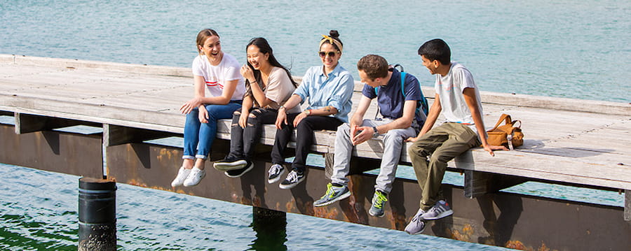 Group of students sitting on a pier